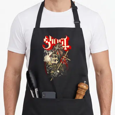 Chalice ghost apron - Skeleton in mitre holding chalice and staff under red GHOST text — shown on a black cotton canvas apron against a white background