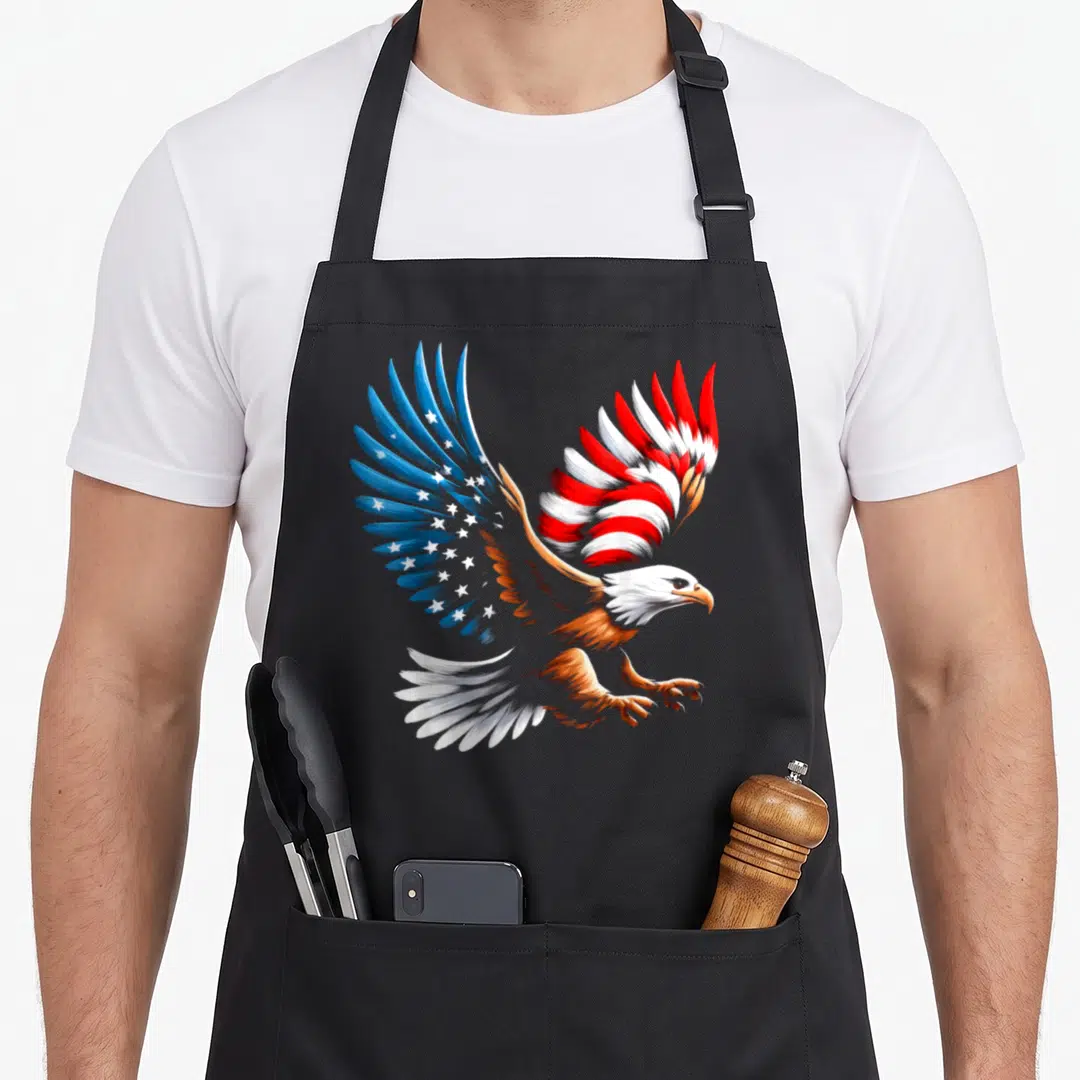 Bald eagle patriotic 4th of july apron - Realistic bald eagle with spread wings painted with blue stars and red white — shown on a black cotton canvas apron against a white background