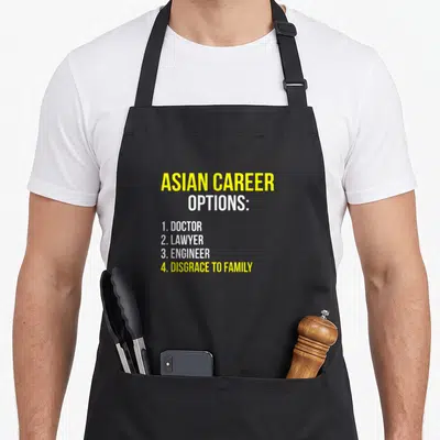 Career asian apron - Yellow and white text listing doctor lawyer engineer and disgrace to family career options — shown on a black cotton canvas apron against a white background