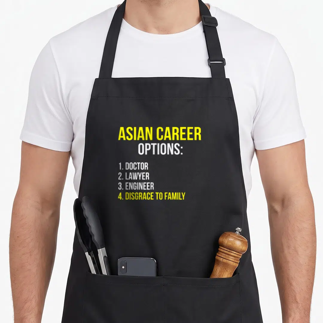 Career asian apron - Yellow and white text listing doctor lawyer engineer and disgrace to family career options — shown on a black cotton canvas apron against a white background