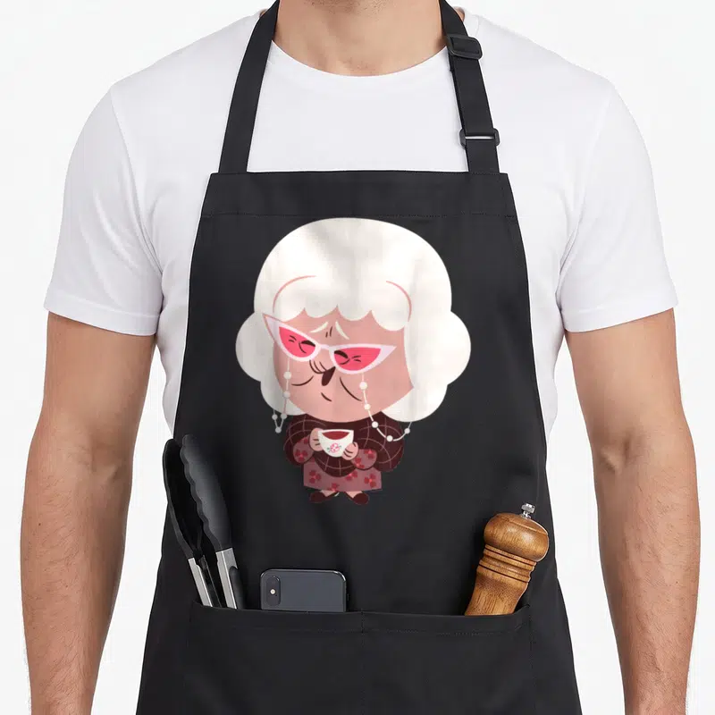 Emotion face apron - Cartoon elderly woman with pink glasses and teacup in white pink brown — shown on a black cotton canvas apron against a white background
