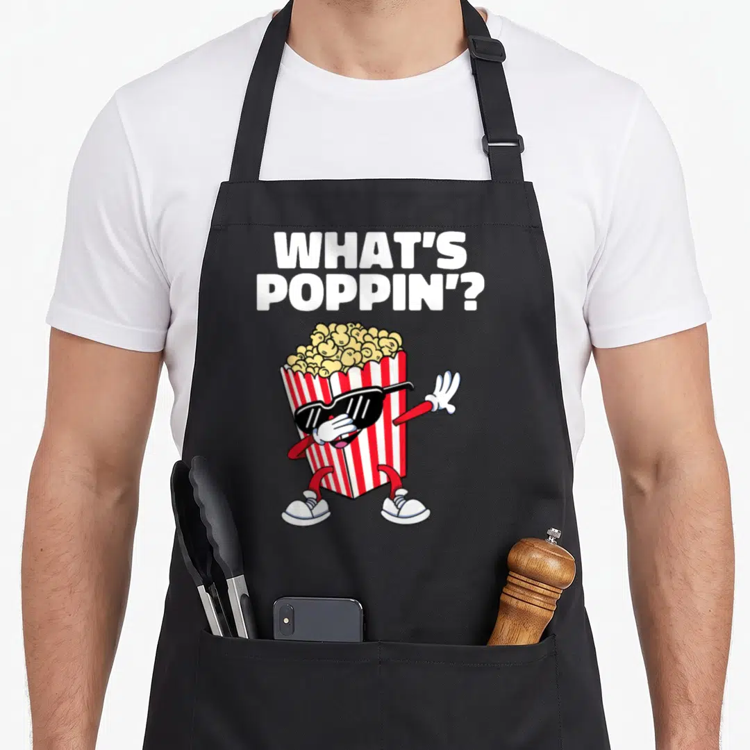 Dabbing popcorn apron - Cartoon popcorn box with sunglasses doing the dab pose under stacked white text — shown on a black cotton canvas apron against a white background