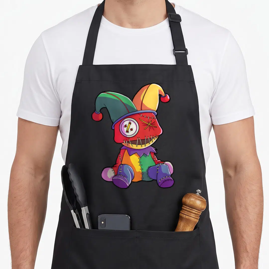 Carnival cottage apron - Cartoon stitched jester doll with button eye and multicolored patchwork body wearing a jester — shown on a black cotton canvas apron against a white background