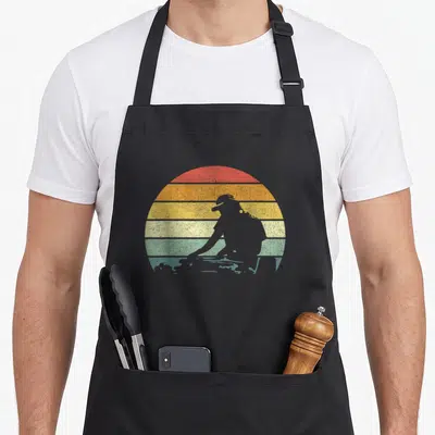 Disc robin lover apron - grey person silhouette in front of red orange yellow green grey striped sun — shown on a black cotton canvas apron against a white background