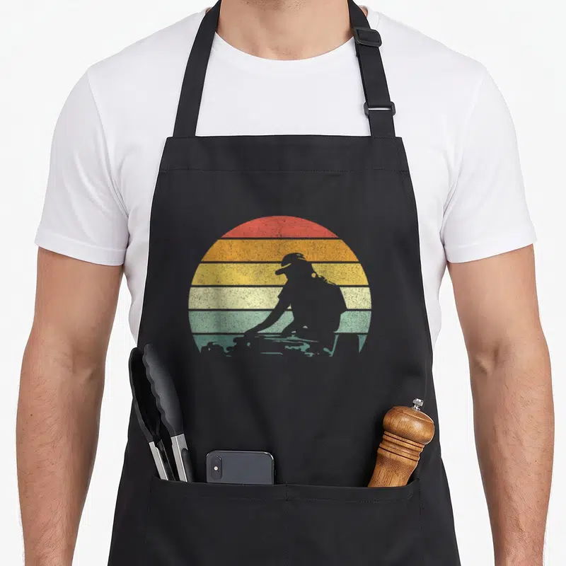 Disc robin lover apron - grey person silhouette in front of red orange yellow green grey striped sun — shown on a black cotton canvas apron against a white background