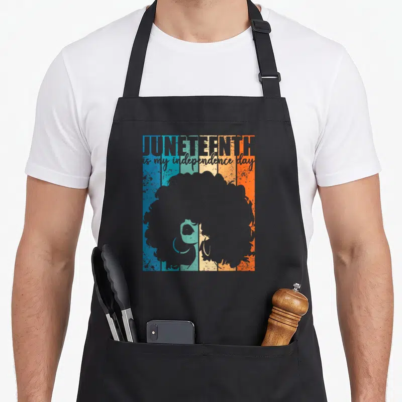 Juneteenth independence apron - Retro woman silhouette with afro over blue teal cream orange grey stripes and stacked — shown on a black cotton canvas apron against a white background