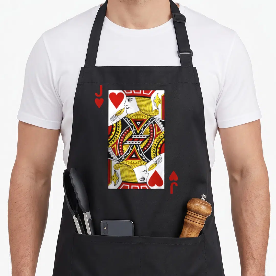 Blackjack jack apron - Red and yellow jack of hearts playing card illustration on black fabric — shown on a black cotton canvas apron against a white background