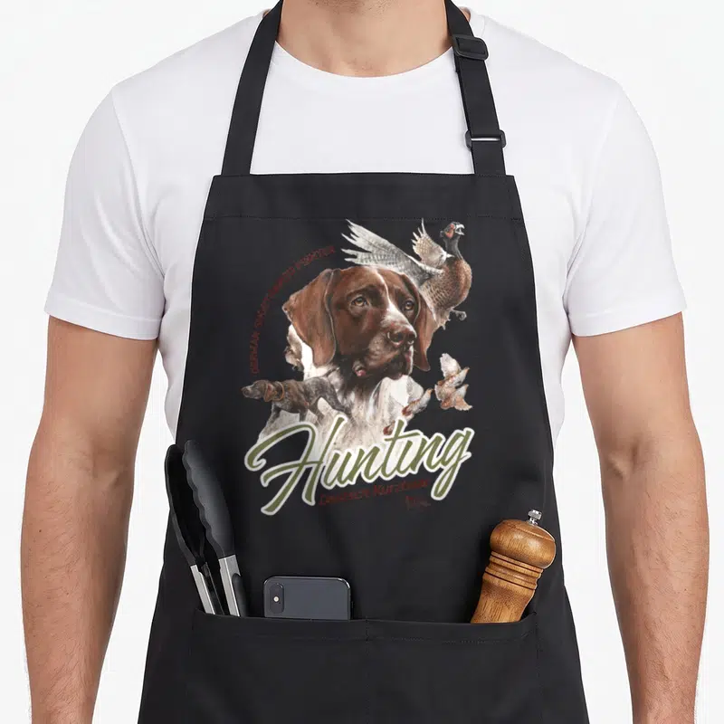 Shorthaired pointer dog apron - Realistic German Shorthaired Pointer head, pheasant, quail, and Hunting text in olive — shown on a black cotton canvas apron against a white background