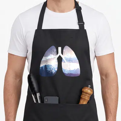 Breathe clean apron - Lung silhouette containing blue purple mountains forests and white tree branch bronchial tubes — shown on a black cotton canvas apron against a white background
