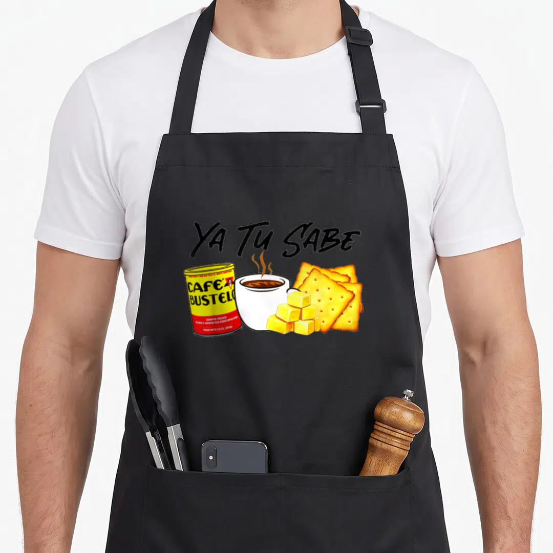 Cafecito mexican apron - Ya Tu Sabe text above Bustelo can, coffee cup, and crackers in cartoon style — shown on a black cotton canvas apron against a white background