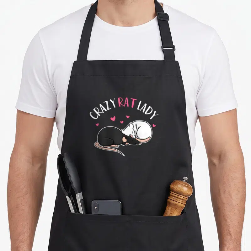 Funny crazy rat lady apron - Two curled rats under arched text with scattered pink hearts in cartoon style — shown on a black cotton canvas apron against a white background