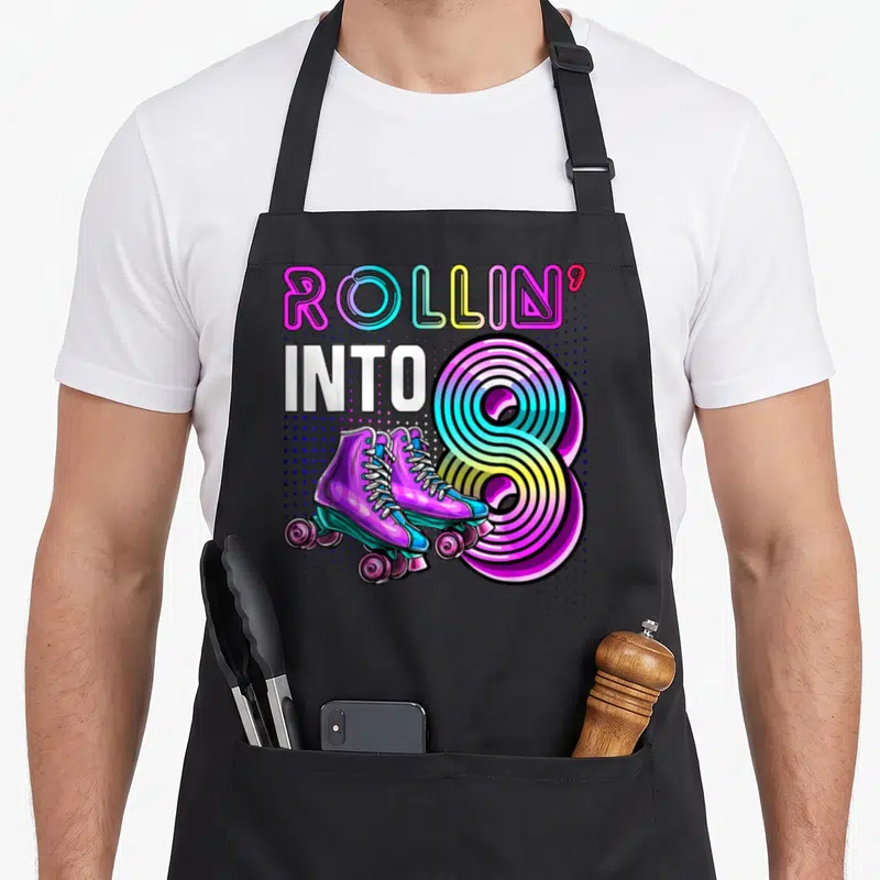 Rollin birthday apron - Retro roller skates overlapping a large number 8 with ROLLIN INTO text — shown on a black cotton canvas apron against a white background