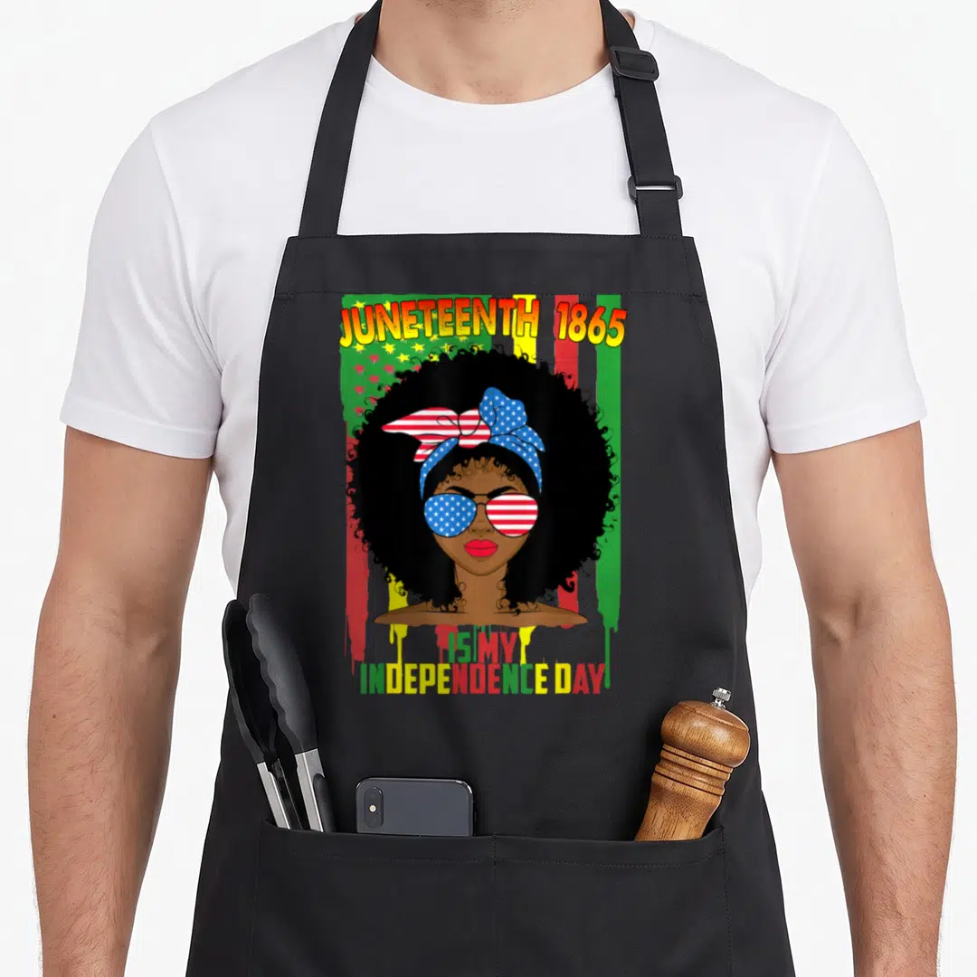 Juneteenth independence 4th of july apron - Cartoon woman with afro and flag sunglasses under JUNETEENTH 1865 text — shown on a black cotton canvas apron against a white background
