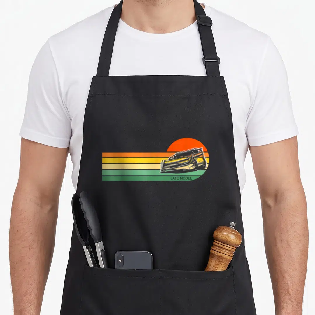 Sunset track apron - Retro race car on orange sun with horizontal stripes and LATE MODEL text — shown on a black cotton canvas apron against a white background