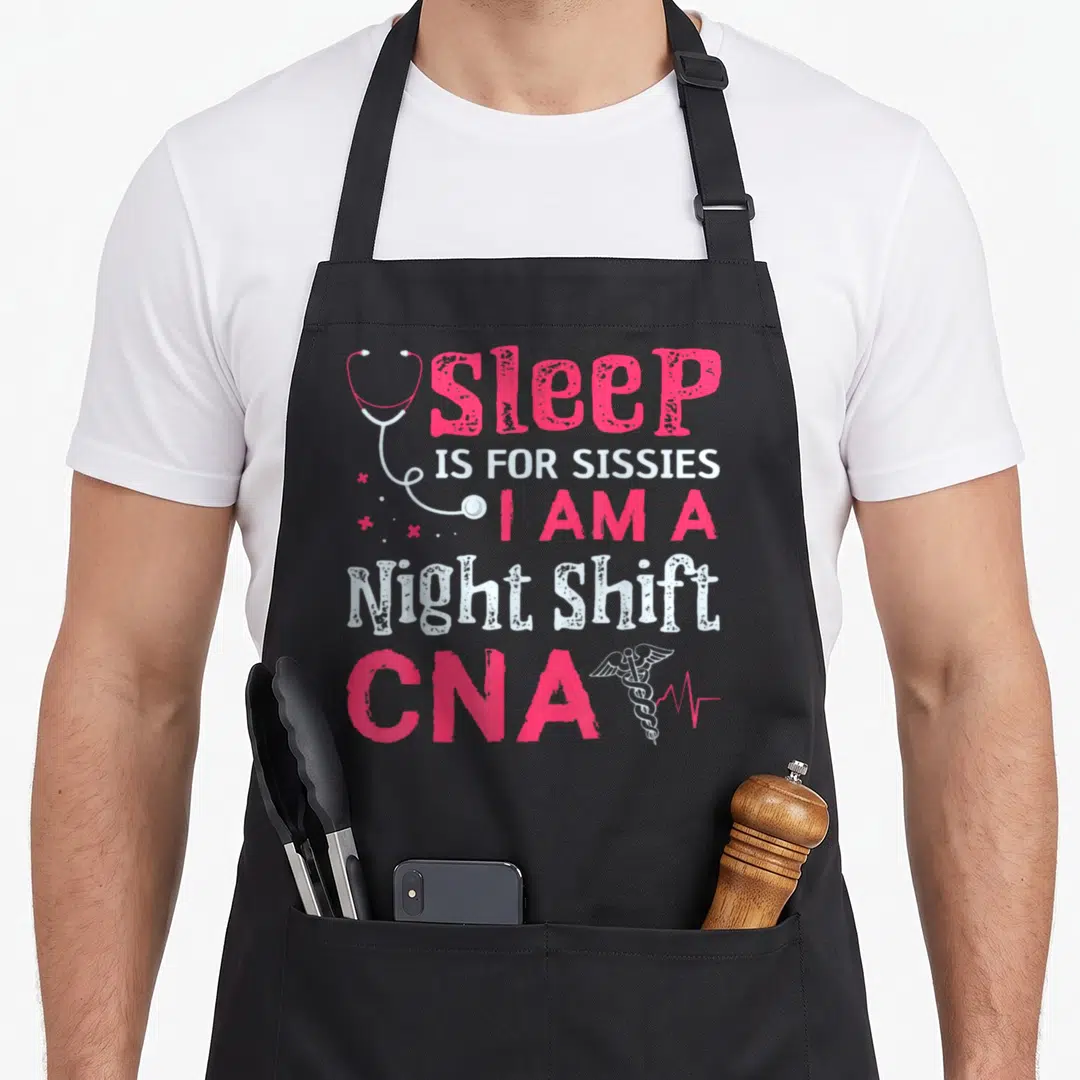 Nurse nursing aprons - Distressed pink and white text reading sleep is for sissies I am a night shift CNA — shown on a black cotton canvas apron against a white background