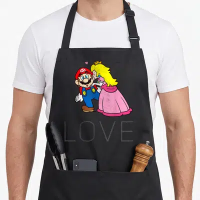 Kiss princess apron - Mario and Peach cartoon embrace with small heart and LOVE text below — shown on a black cotton canvas apron against a white background