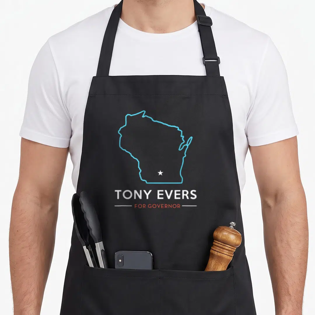 Tony wisconsin apron - Blue Wisconsin outline with white star and TONY EVERS FOR GOVERNOR text — shown on a black cotton canvas apron against a white background