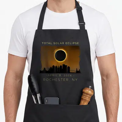 Total solar new york apron - Total Solar Eclipse April 8 2024 Rochester NY skyline gold black orange art — shown on a black cotton canvas apron against a white background