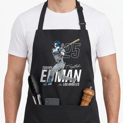 Tommy baseball apron - Tommy Edman baseball player swinging bat with number 25 and Los Angeles text in distressed style — shown on a black cotton canvas apron against a white background