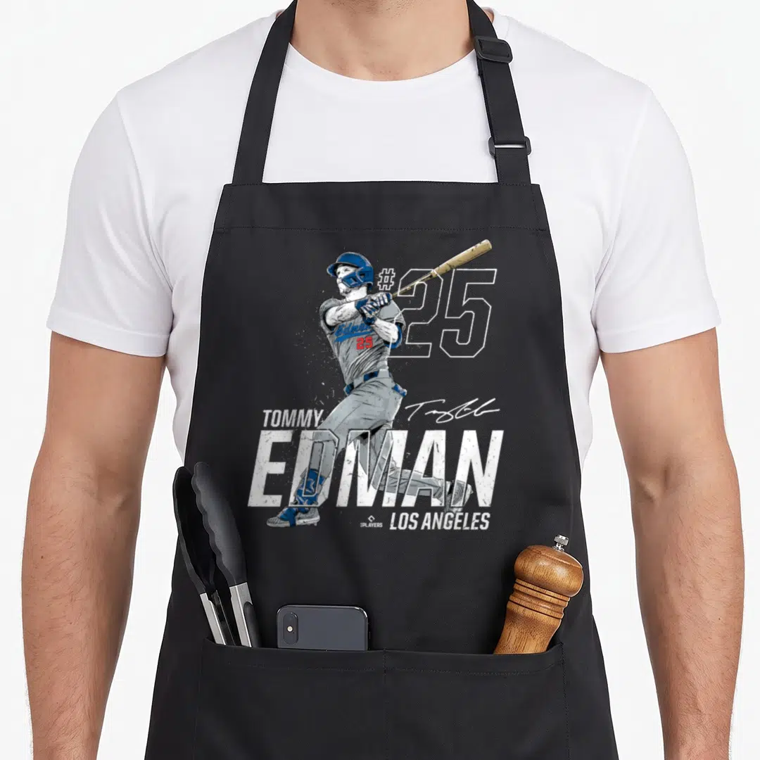 Tommy baseball apron - Tommy Edman baseball player swinging bat with number 25 and Los Angeles text in distressed style — shown on a black cotton canvas apron against a white background