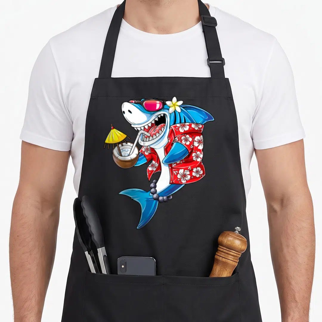 Shark hawaiian apron - Cartoon shark in red floral shirt and sunglasses holding a coconut drink with a yellow umbrella — shown on a black cotton canvas apron against a white background