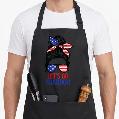 Brandon messy aprons - Woman silhouette with US flag sunglasses and LET'S GO BRANDON text — shown on a black cotton canvas apron against a white background