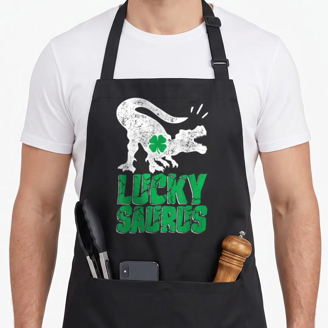 Luckysaurus st patrick day aprons - White dinosaur silhouette with green four-leaf clover and lucky saurus text — shown on a black cotton canvas apron against a white background
