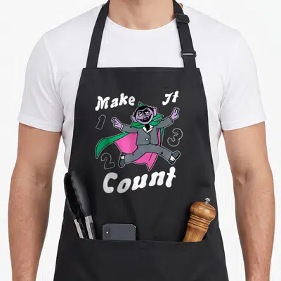 Count counting apron - Cartoon purple vampire jumping among numbers 1, 2, 3 with text Make It Count — shown on a black cotton canvas apron against a white background