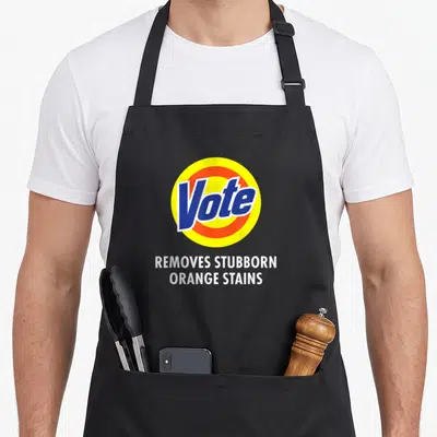 Vote novelty apron - Blue Vote logo in yellow orange circle with white text below — shown on a black cotton canvas apron against a white background