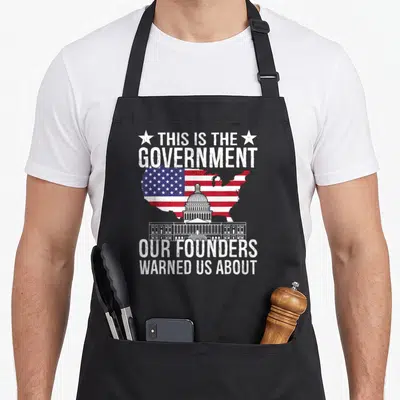 Government us aprons - Distressed USA map with Capitol dome and founders warning quote in white red blue — shown on a black cotton canvas apron against a white background