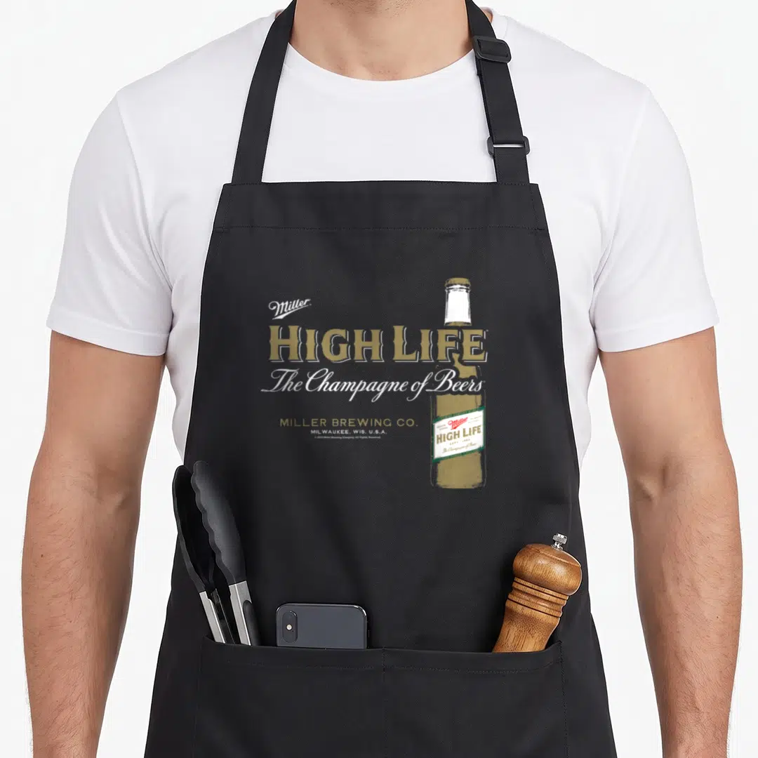 Miller champagne apron - Vintage gold beer bottle with Miller High Life text and white script on grey background — shown on a black cotton canvas apron against a white background
