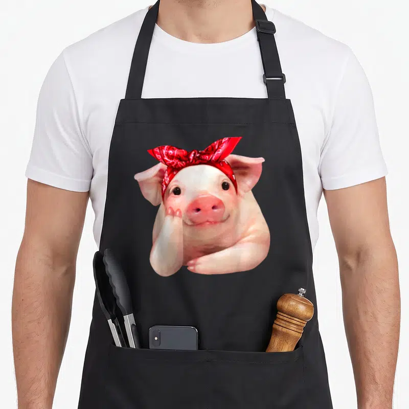 Bandanna i love my pig apron - Realistic pink pig wearing a red bandana tied in a bow on its head — shown on a black cotton canvas apron against a white background
