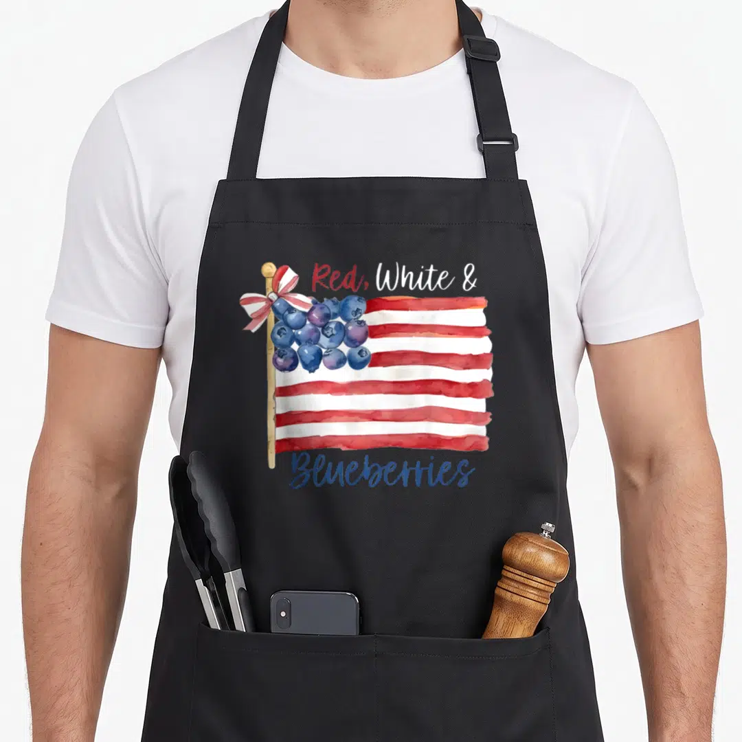 Funny blueberries apron - Watercolor flag with red white stripes and blueberry cluster canton — shown on a black cotton canvas apron against a white background
