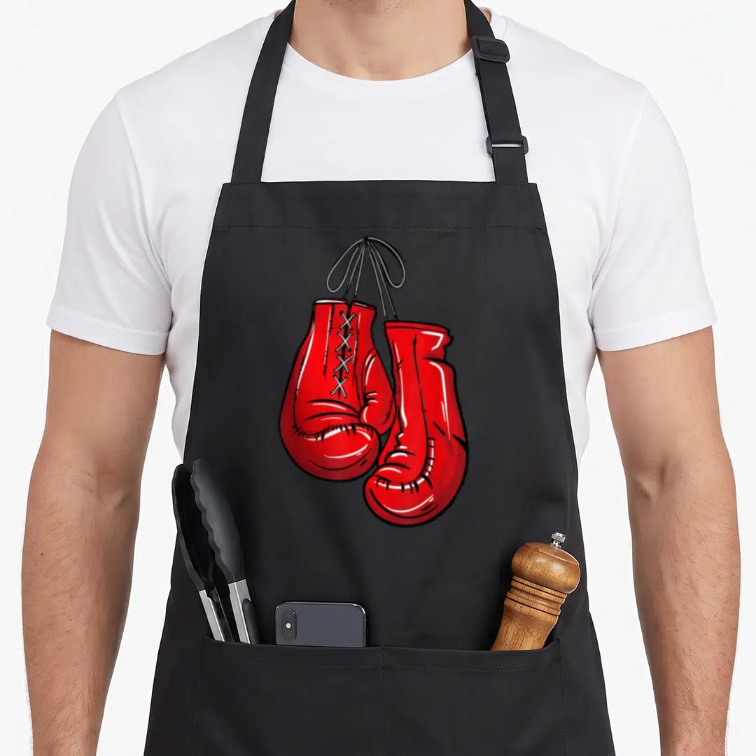 Illustration gloves and apron - Two red boxing gloves hanging by black laces in a cartoon illustration style — shown on a black cotton canvas apron against a white background