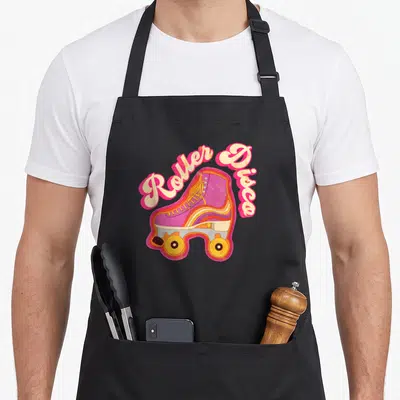 Disco skating 70s apron - Purple roller skate graphic with Roller Disco text in pink and cream retro style — shown on a black cotton canvas apron against a white background