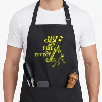 Infantry monk apron - Yellow distressed mortar on tripod next to stacked text Keep Calm And Fire For Effect — shown on a black cotton canvas apron against a white background