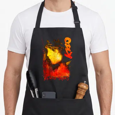 Tear ozzy osbourne apron - Distressed yellow face with red NO MORE TEARS text and abstract red shapes — shown on a black cotton canvas apron against a white background