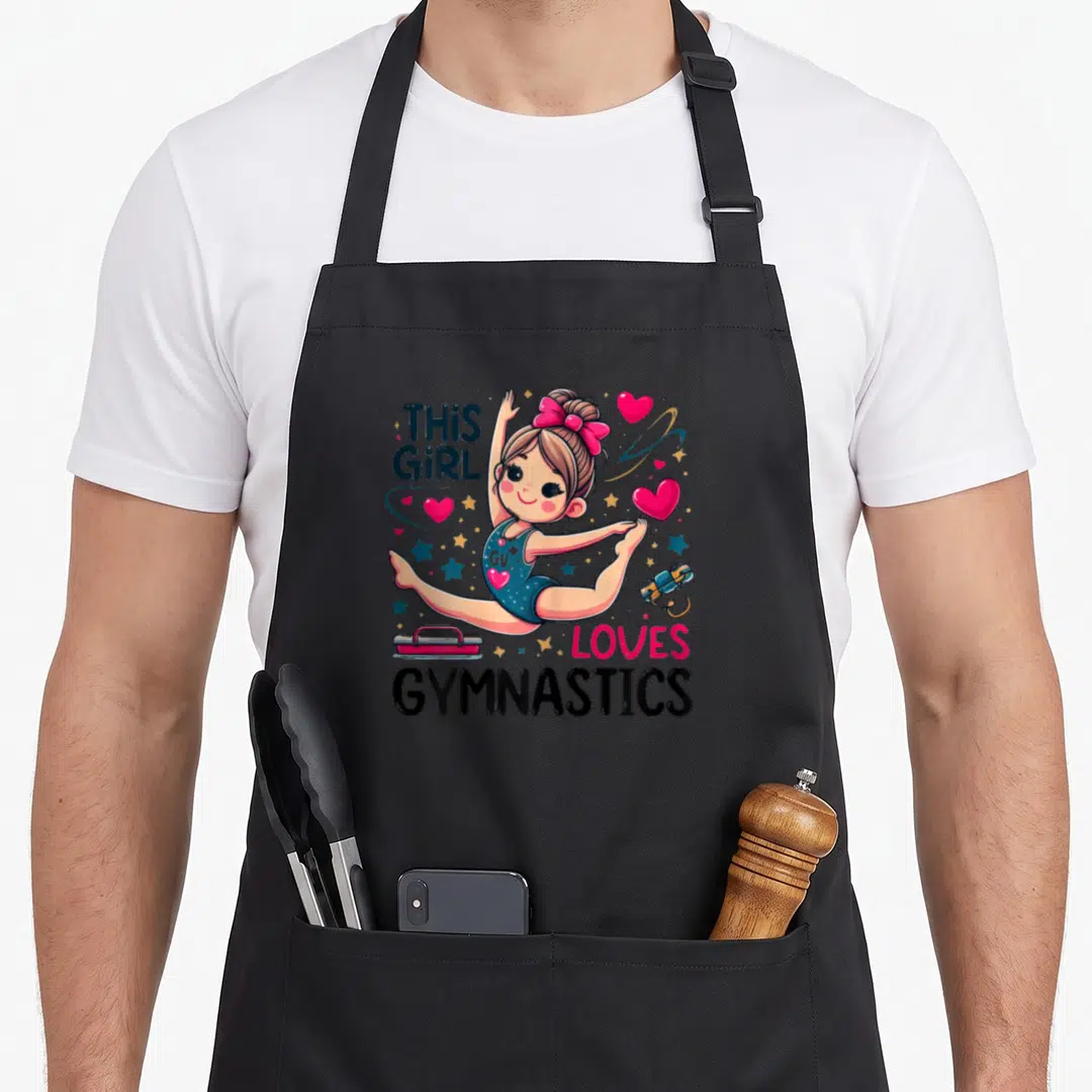 Sport gymnastic apron - Cartoon gymnast doing splits with THIS GIRL LOVES GYMNASTICS text, pink hearts, and gym gear — shown on a black cotton canvas apron against a white background
