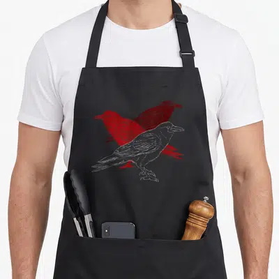 Vintage ravens aprons - Three overlapping crows in white and red with distressed texture — shown on a black cotton canvas apron against a white background