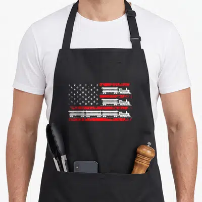Model patriotic apron - Distressed red and white flag design with white train silhouettes replacing stripes — shown on a black cotton canvas apron against a white background
