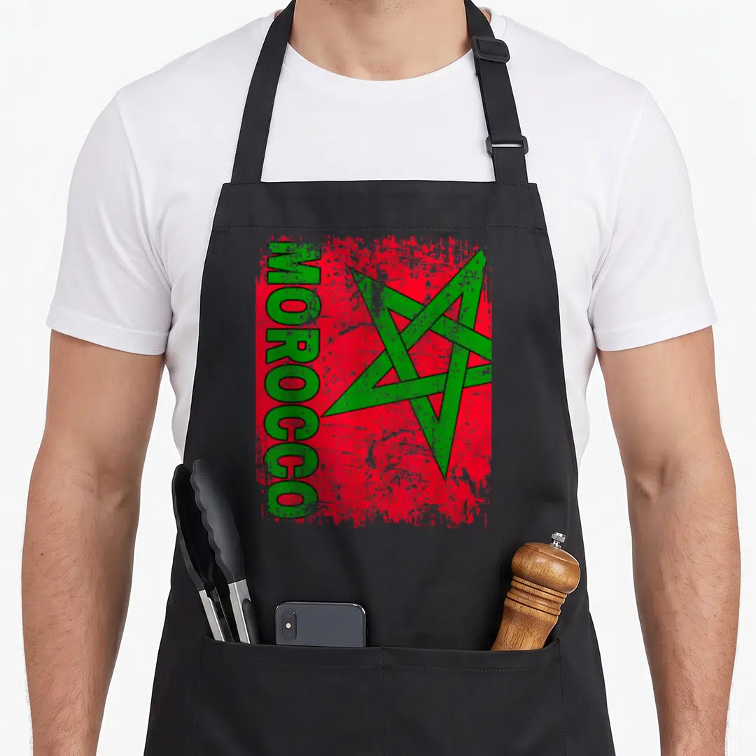 Morocco moroccan girl apron - Vertical green MOROCCO text beside distressed red flag with green pentagram — shown on a black cotton canvas apron against a white background