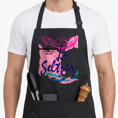 Pamplemousse halloween apron - La Seltzer text over pink teal blue paint strokes with natural PAMPLEMOUSSE SPARKLING — shown on a black cotton canvas apron against a white background