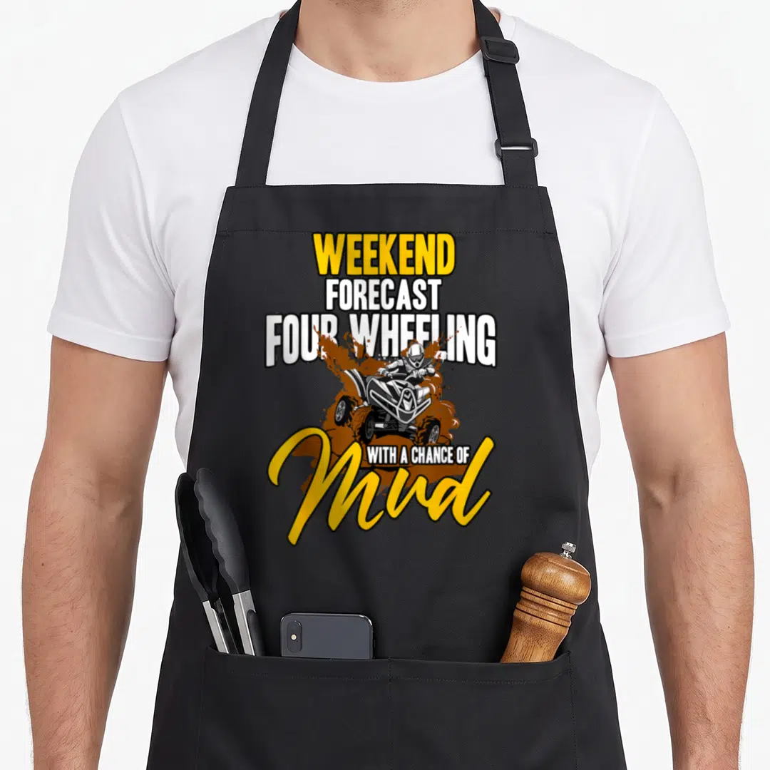 Weekend atv lover apron - Stacked text WEEKEND FORECAST FOUR WHEELING WITH A CHANCE OF Mud around cartoon ATV rider — shown on a black cotton canvas apron against a white background