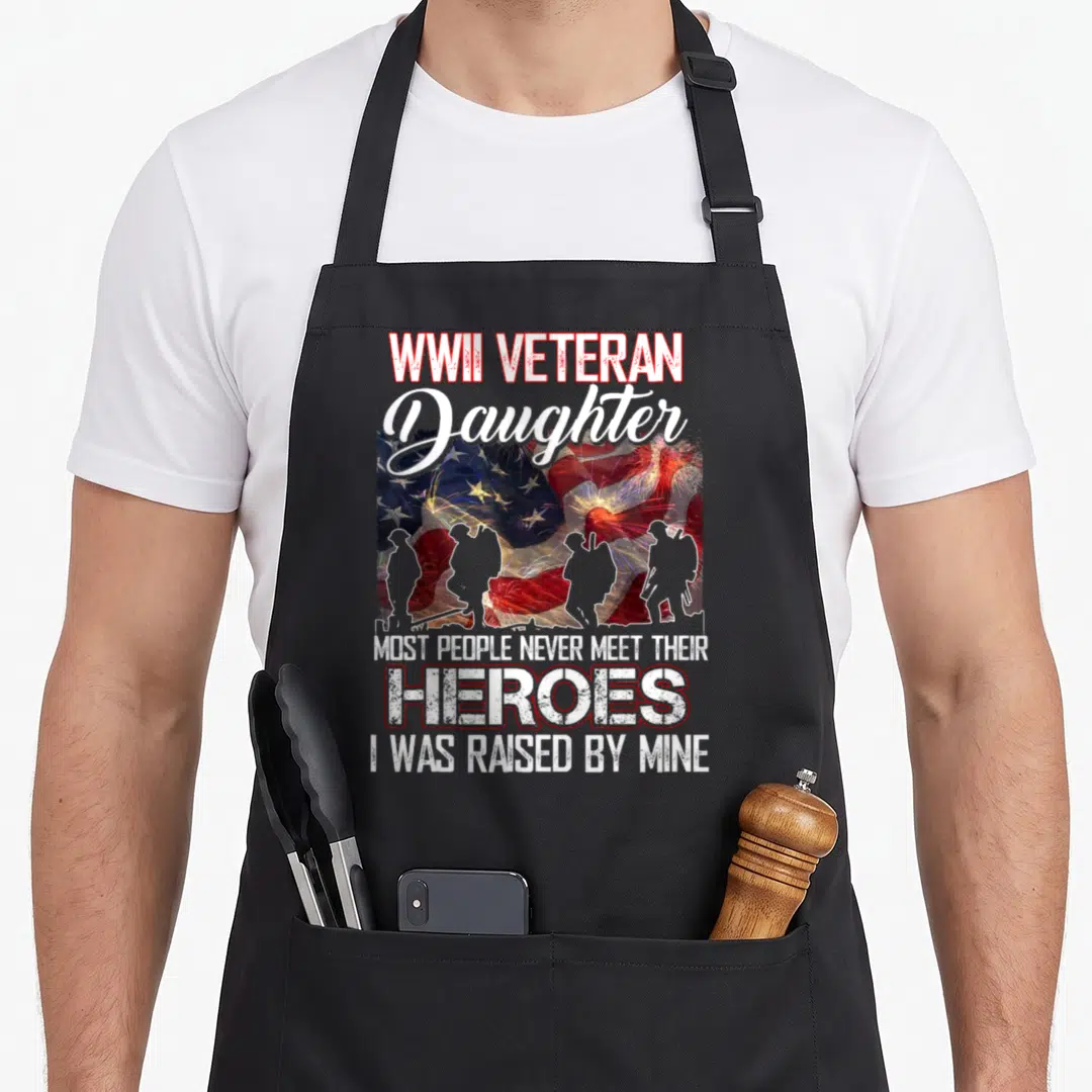 Veteran people meet apron - Waving USA flag with four soldier silhouettes and fireworks behind text reading WWII — shown on a black cotton canvas apron against a white background