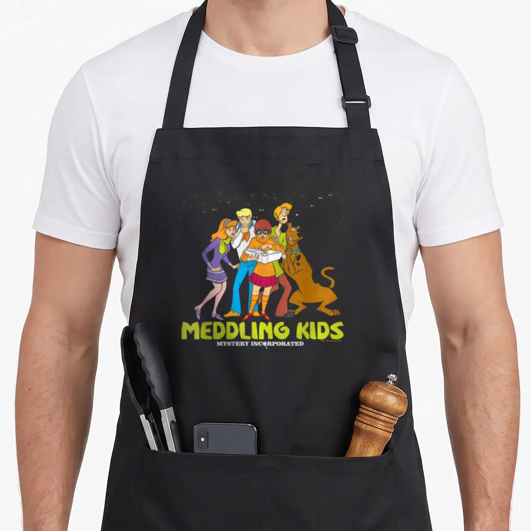 Meddling have better apron - Five cartoon characters holding a book with grey monster silhouettes and yellow stacked — shown on a black cotton canvas apron against a white background