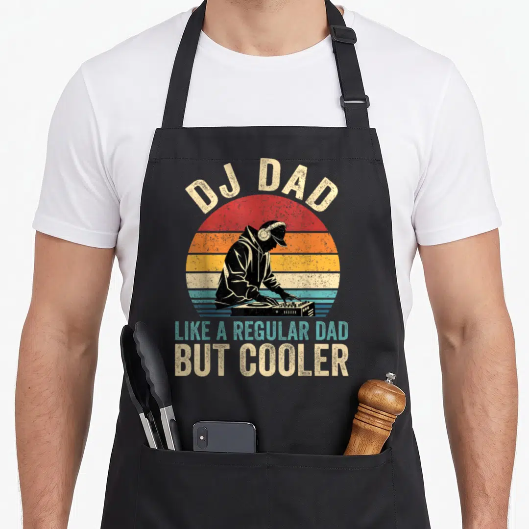 But cooler father day apron - Retro DJ silhouette in front of striped sun with arched text reading DJ Dad Like — shown on a black cotton canvas apron against a white background