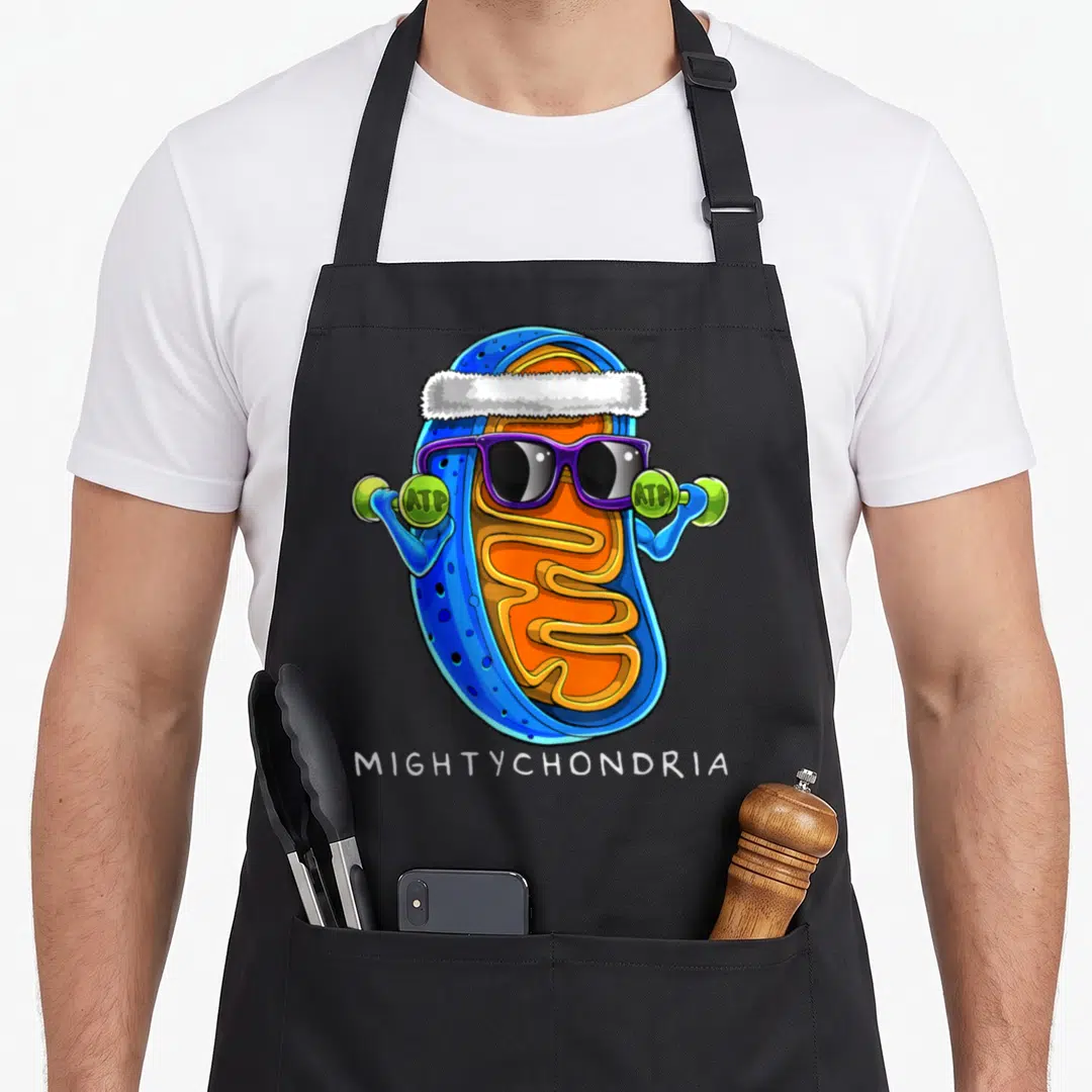 Mightychondria teacher apron - Cartoon mitochondrion lifting ATP weights wearing purple sunglasses and white fur hat — shown on a black cotton canvas apron against a white background