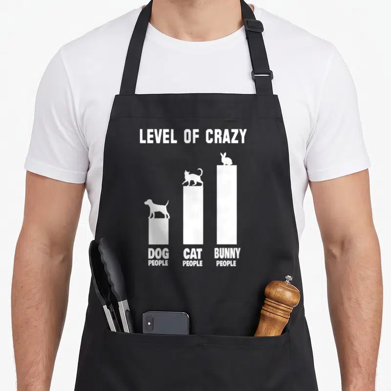 Rabbit owner bunny apron - White bar chart showing bunny people at highest level of crazy above dog and cat people — shown on a black cotton canvas apron against a white background