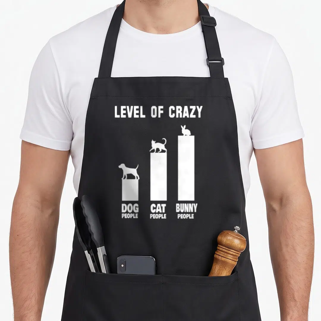 Rabbit owner bunny apron - White bar chart showing bunny people at highest level of crazy above dog and cat people — shown on a black cotton canvas apron against a white background