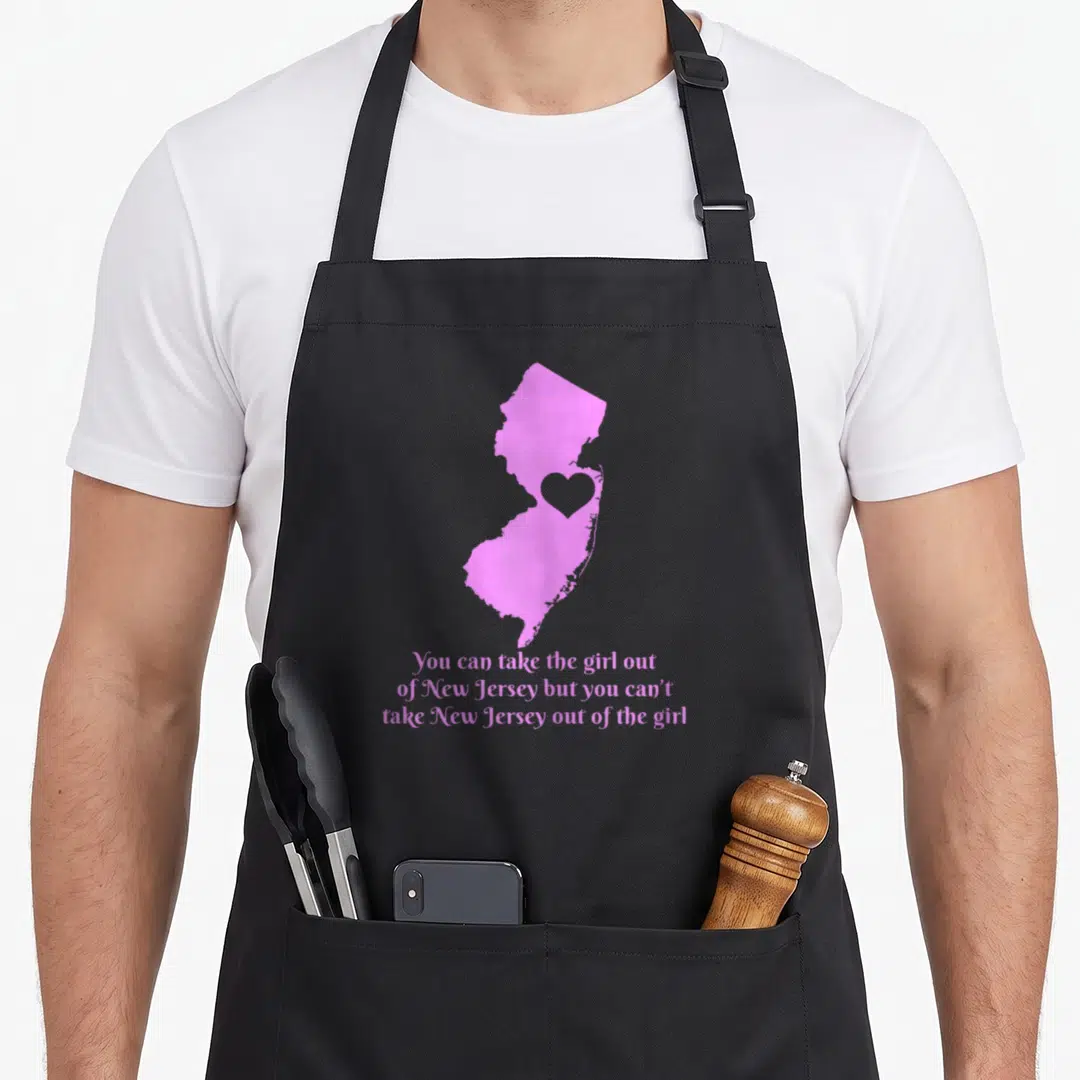 Jersey state pride apron - Pink New Jersey map silhouette with grey heart cutout and three lines of pink script text — shown on a black cotton canvas apron against a white background